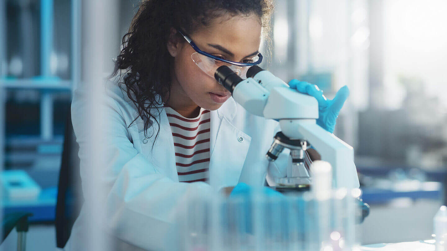 Scientist examining a sample under a microscope